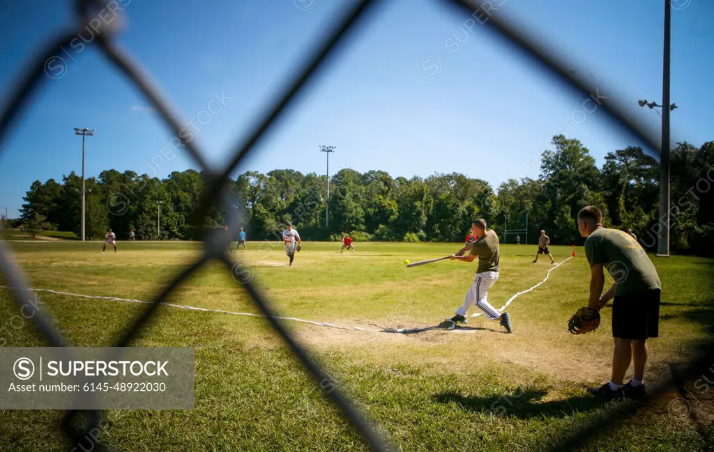 Marines and sailors with 2nd Battalion, 8th Marine Regiment, compete in a softball game as part of the 2/8 Olympics. The unit gave their weathered camouflage utilities a week-long break to carry out a battalion-size Olympics promoting unit cohesion and competitive spirits.