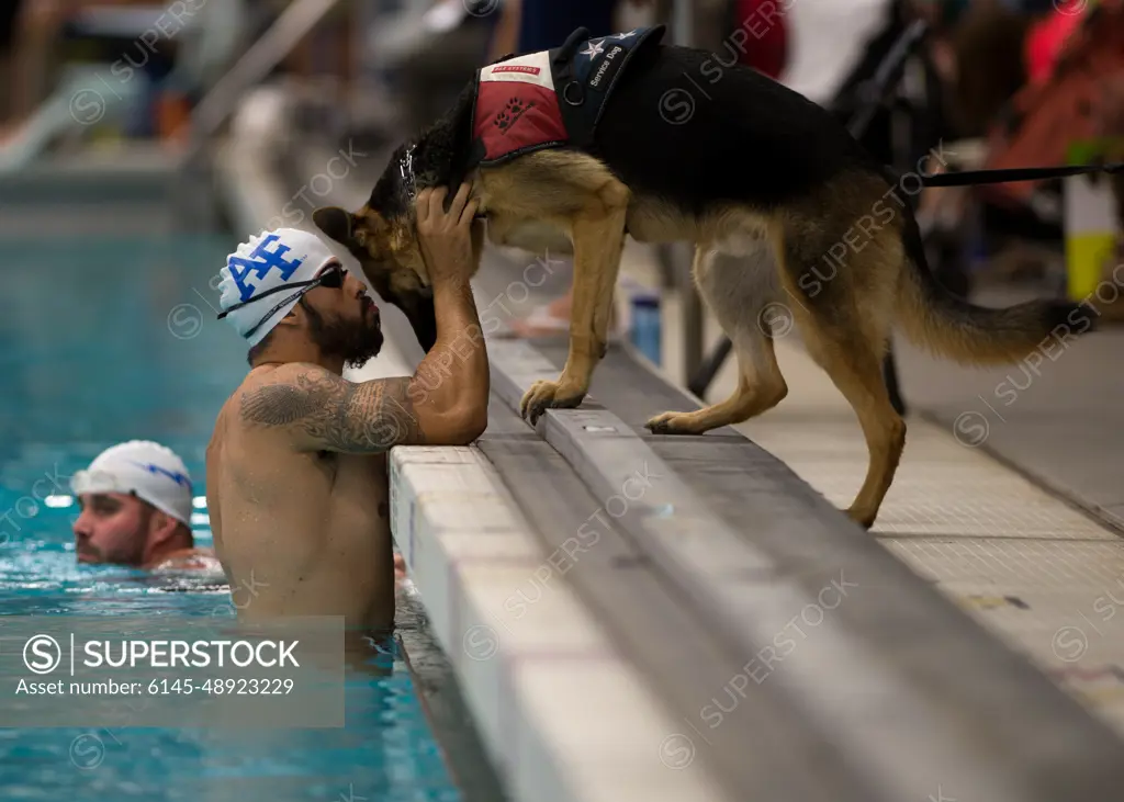 Air Force athlete August O'Niell kisses his service dog, Kai, during warmups for the swimming portion of the 2014 Warrior Games Sept. 30, 2014, at the U.S. Olympic Training Center in Colorado Springs, Colo. The Warrior Games consist of athletes from the Defense Department, who compete in Paralympic-style events for their respective military branch.