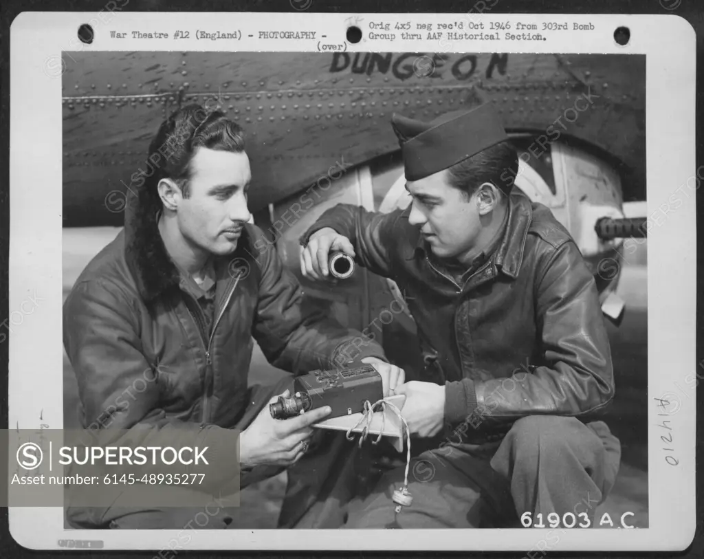 Crew Members Of The 303Rd Bomb Group Check The Machine Gun Camera Which Will Be Installed In The Boeing B-17 "Flying Fortress" In The Background. England, 13 March 1945.