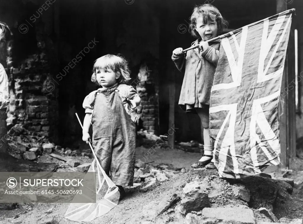 Ve Day in London, 8 May 1945 Two small girls waving their flags in the rubble of Battersea, snapped by an anonymous American photographer.