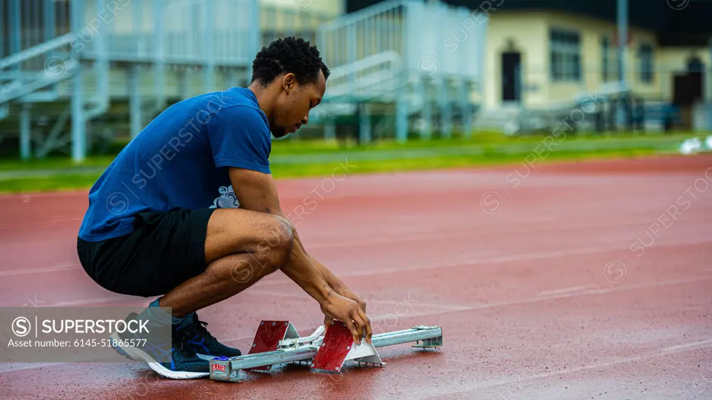 A participant from Team Misawa sets his starting blocks for a track and field event during the first-ever Sakura Olympics at Misawa Air Base, Japan, April 22, 2022. Over 40 people from around Misawa Air Base sat on the Sakura Olympics committee, organizing sports such as basketball, soccer, and powerlifting during this joint bilateral event.