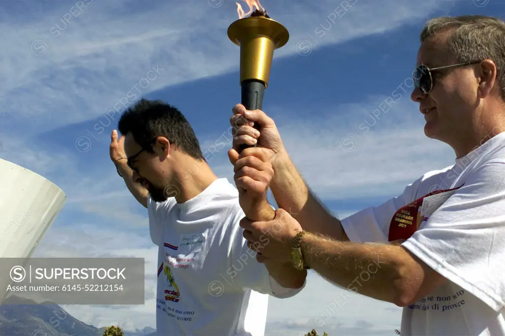 A Special Olympics Athlete (left), and US Air Force Command CHIEF MASTER Sergeant Bruce Reid, 31ST Fighter Wing, Aviano Air Base, Italy, get ready to light the torch at the opening ceremony of the Special Olympics. Aviano's Community Special Games is an annual amateur sports competition organized in the spirit of the Special Olympics. A Special Olympics Athlete (left), and US Air Force Command Chief Master Sergeant Bruce Reid, 31ST Fighter Wing, Aviano Air Base, Italy, get ready to light the torch at the opening ceremony of the Special Olympics.  Aviano's Community Special Games is an annual amateur sports competition organized in the spirit of the Special Olympics.