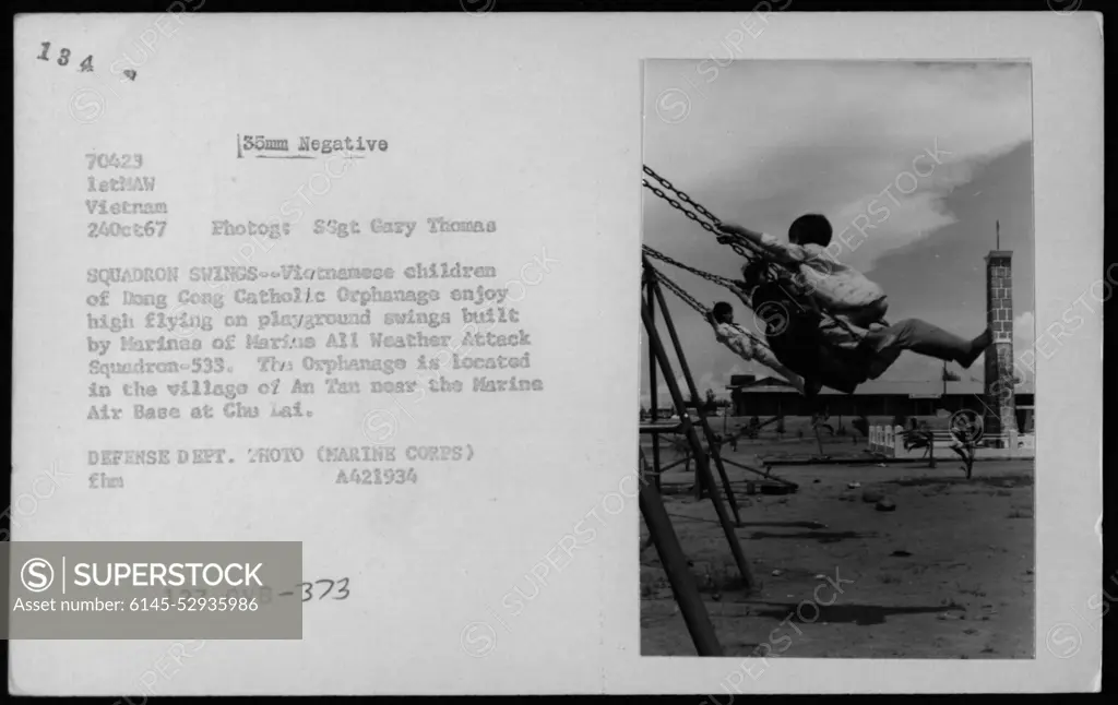 Vietnamese children at the Long Cong Catholic Orphanage in An Tan village near Chu Lai Marine Air Base enjoy playing on playground swings built by Marines from Marine All Weather Attack Squadron-533 on October 24, 1967. This photograph, taken by SSgt Gary Thomas, captures a moment of joy in the lives of Vietnamese civilians amidst the backdrop of the Vietnam War.