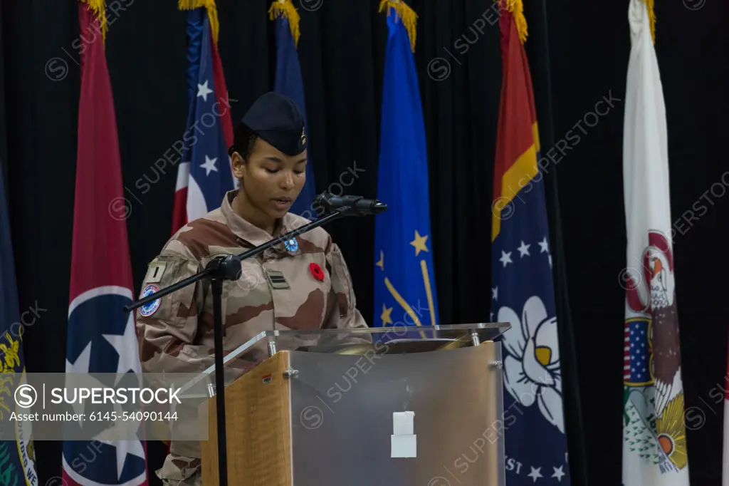 French Army 1st Lt. Francesca narrates the Remembrance Day ceremony inside the Morale, Welfare, and Recreation building, Camp Arifjan, Kuwait, Nov. 11, 2022. Distinguished visitors, veterans, friends, and family members gathered at the MWR building to commemorate all wars and honor the service of armed forces past and present.