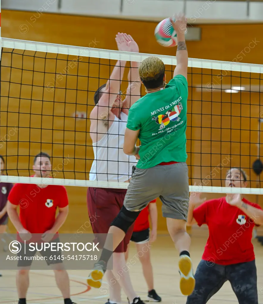 Airmen from the 702nd Munitions Support Squadron (in green) compete against Airmen from the 703rd MUNSS in a volleyball game during the 2022 MUNSS Olympics at Spangdahlem Air Base, Germany, August 5, 2022. Members of the MUNSS sites competed in various activities including soccer, kickball, flag football, powerlifting, running and volleyball. This is the first MUSSS Olympics held since 2019. It is designed for MUNSS personnel to network and create face-to-face relationships, which enhances mission success.