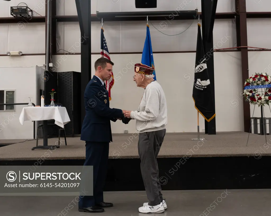 U.S. Air Force Col. Scott Mills, 355th Wing commander, presents Harvey, Horn, former prisoner of war, with a POW/MIA flag carried during a remembrance 5k at the POW/MIA Recognition Ceremony at the Pima Air and Space Museum in Tucson, Arizona, Sept. 16, 2022. Established in 1979 and celebrated on the third Friday in September, POW/MIA Recognition Day honors those who were held captive and returned, as well as those who remain missing.