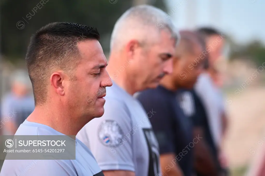 Chief Master Sgt. Justin Stoltzfus (left), 39th Air Base Wing command chief, prays during a POW/MIA remembrance ceremony at Incirlik AB, Turkey, Sept. 16, 2022. Service members and civilians gathered for a 24-hour run in honor of National POW/MIA Recognition Day. Attendees continued to run until the end of the event to remember and honor those Americans who were prisoners of war and those who served and never returned home.