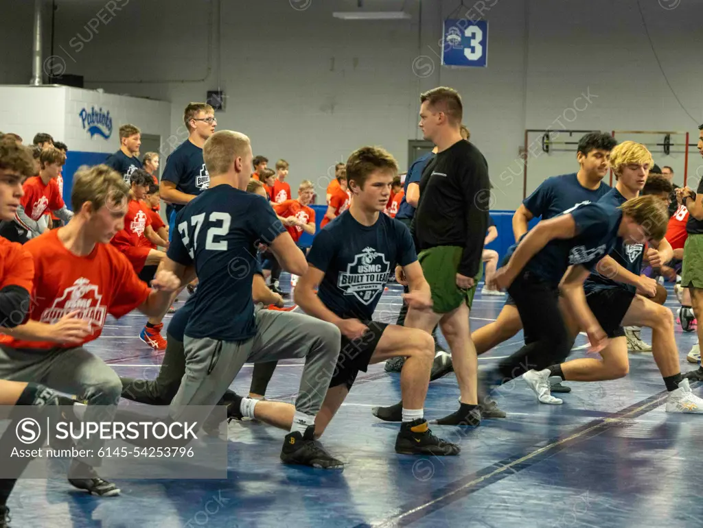 U.S. Marine Corps Sgt. William Larkin, a recruiter with Marine Corps Recruiting Station Columbus, leads warm up exercises with high school wrestlers at the United States Marine Corps Sports Leadership Academy October 15, 2022, at Olentangy Liberty High School in Columbus, Ohio. The United States Marine Corps Sports Leadership Academy is a free event that helps high school wrestlers strengthen their wrestling skills and learn leadership principles from Marines.