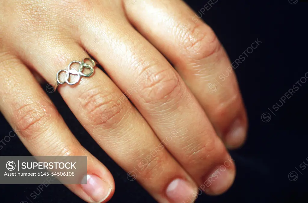 Straight on, extreme close-up of the right hand of Olympic Gold Medalist Nancy Johnson as she shows off a ring of Olympic Rings she says was made following the 1996 Olympics in Atlanta, Georgia. Nancy won the Women's 10-Meter Air Rifle Competition claiming the first gold medal of the 2000 Olympic games in Sydney, Australia, September 16th, 2000. Base: Sydney State: New South Wales Country: Australia (AUS)