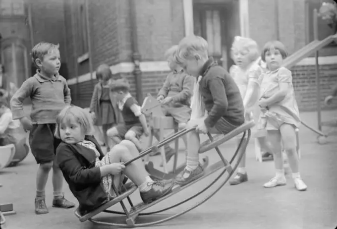 Boys Lessons Provide Wartime Toys, London, England, UK, 1943 In the playground of an infant school in north London, young children play on the new see-saw made for them by the boys of Medburn Road School from salvaged materials.