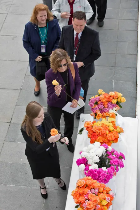 Following this year's Day of Remembrance ceremony at the Kennedy Space Center Visitor Complex, guests pick up flowers to place at the Space Mirror Memorial. The names of fallen astronauts from Apollo 1, Challenger and Columbia, as well as the astronauts who perished in training and commercial airplane accidents are emblazoned on the monument. Each year spaceport employees and guests join others throughout NASA honoring the contributions of astronauts who have perished in the conquest of space.