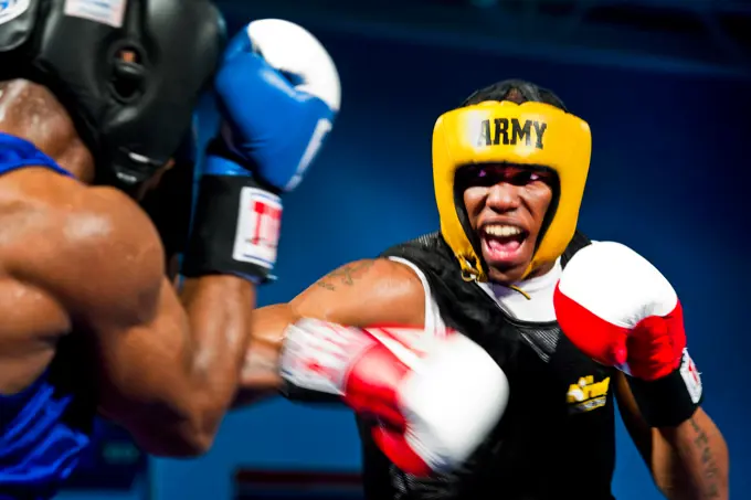 LACKLAND AIR FORCE BASE, Texas-- Spc. Zacchaeus Hardrick (right), a boxer representing the U.S. Army team, punches Air Force Staff Sgt. Gary Griffin (left), during their bout at the 2011 Armed Forces Boxing Championship at the Chaparral Fitness Center, Feb. 15, 2011. The AFBC is an elite competition between military service branches. Winning a gold medal in the event qualifies the athlete to compete in the 2012 Olympic team trials.