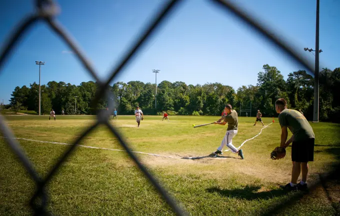 Marines and sailors with 2nd Battalion, 8th Marine Regiment, compete in a softball game as part of the 2/8 Olympics. The unit gave their weathered camouflage utilities a week-long break to carry out a battalion-size Olympics promoting unit cohesion and competitive spirits.