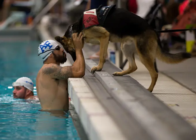 Air Force athlete August O'Niell kisses his service dog, Kai, during warmups for the swimming portion of the 2014 Warrior Games Sept. 30, 2014, at the U.S. Olympic Training Center in Colorado Springs, Colo. The Warrior Games consist of athletes from the Defense Department, who compete in Paralympic-style events for their respective military branch.