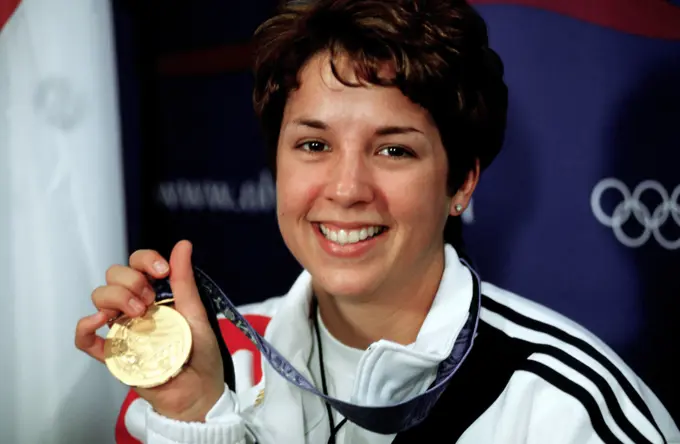 Nancy Johnson holds up the gold medal she won in the 10-Meter Air Rifle Competition at the 2000 Olympic games in Sydney, Australia, September 16th, 2000. Nancy is married to US Army STAFF Sergeant Ken Johnson (Not shown) who is also on the US shooting team. Base: Sydney State: New South Wales Country: Australia (AUS)