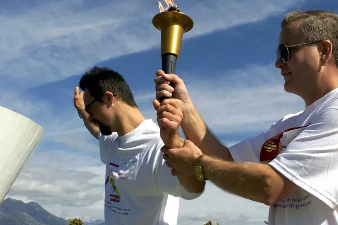 A Special Olympics Athlete (left), and US Air Force Command CHIEF MASTER Sergeant Bruce Reid, 31ST Fighter Wing, Aviano Air Base, Italy, get ready to light the torch at the opening ceremony of the Special Olympics. Aviano's Community Special Games is an annual amateur sports competition organized in the spirit of the Special Olympics. A Special Olympics Athlete (left), and US Air Force Command Chief Master Sergeant Bruce Reid, 31ST Fighter Wing, Aviano Air Base, Italy, get ready to light the torch at the opening ceremony of the Special Olympics.  Aviano's Community Special Games is an annual amateur sports competition organized in the spirit of the Special Olympics.