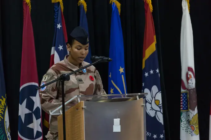 French Army 1st Lt. Francesca narrates the Remembrance Day ceremony inside the Morale, Welfare, and Recreation building, Camp Arifjan, Kuwait, Nov. 11, 2022. Distinguished visitors, veterans, friends, and family members gathered at the MWR building to commemorate all wars and honor the service of armed forces past and present.