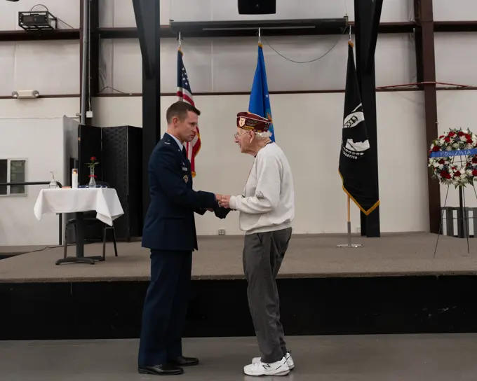 U.S. Air Force Col. Scott Mills, 355th Wing commander, presents Harvey, Horn, former prisoner of war, with a POW/MIA flag carried during a remembrance 5k at the POW/MIA Recognition Ceremony at the Pima Air and Space Museum in Tucson, Arizona, Sept. 16, 2022. Established in 1979 and celebrated on the third Friday in September, POW/MIA Recognition Day honors those who were held captive and returned, as well as those who remain missing.