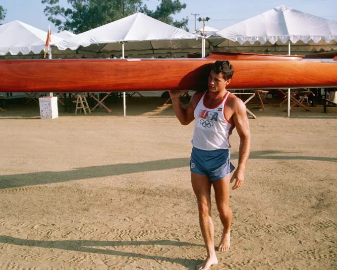 Army National Guard Private First Class Daniel W. Schnurrenberger from Newport Beach, California, carriers his kayak toward the lake prior to competition at the 1984 Summer Olympics. Base: Lake Casitas State: California (CA) Country: United States Of America (USA)