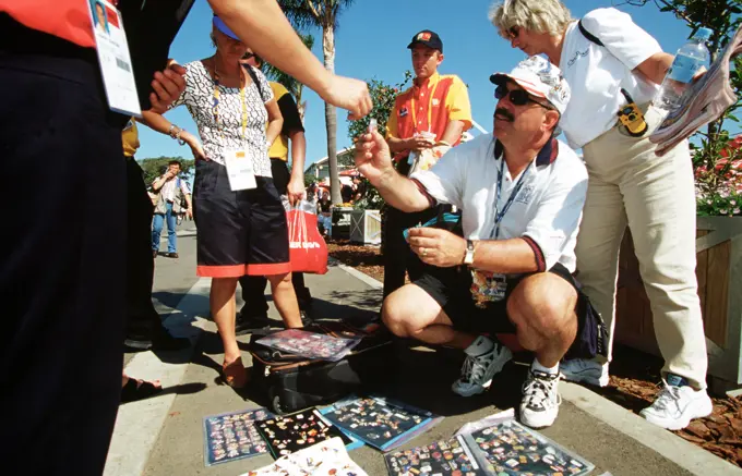 American Bob McKeon, of Poway, California (Kneeling), said the Sydney Olympics is his seventh. McKeon, an avid pin trader and collector, says he brought 20,000 of his 100,000 pin collection to trade with during the sydney 2000 Olympics. Numerous US Department of Defense personnel (Not shown) are taking part in the Olympics, from coaches and support staff to athletes competing in various venues. Base: Sydney State: New South Wales Country: Australia (AUS)