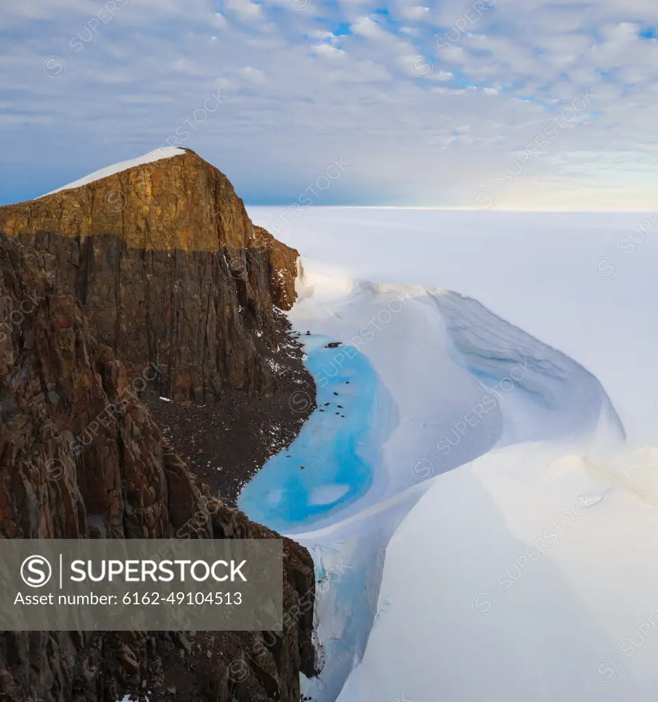 Aerial view of a mountain surrounded by snow in Antarctica