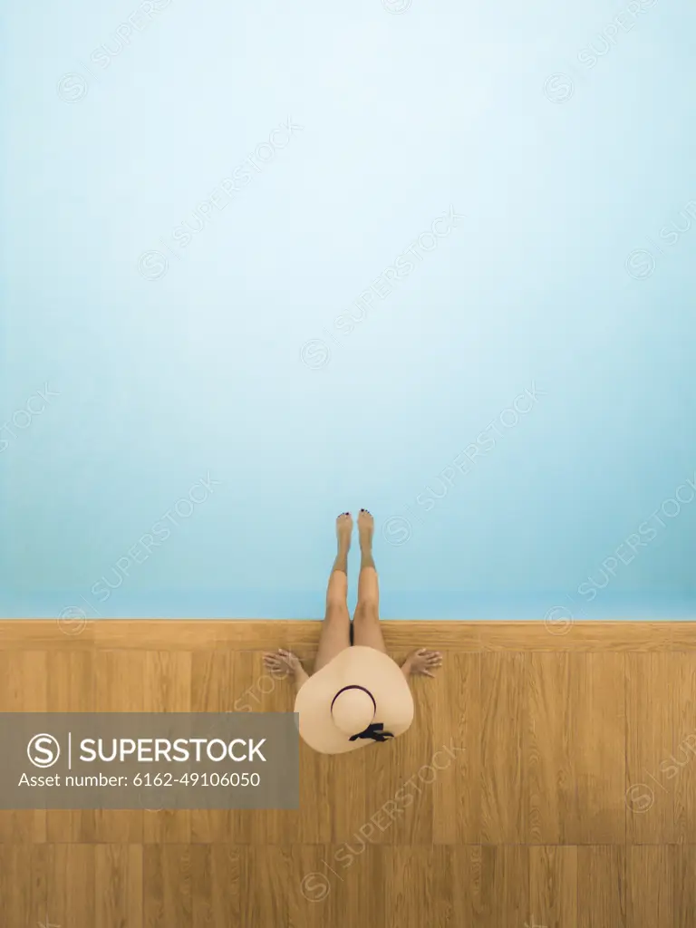 Aerial view of a girl on a poolside, Sicily, Italy.