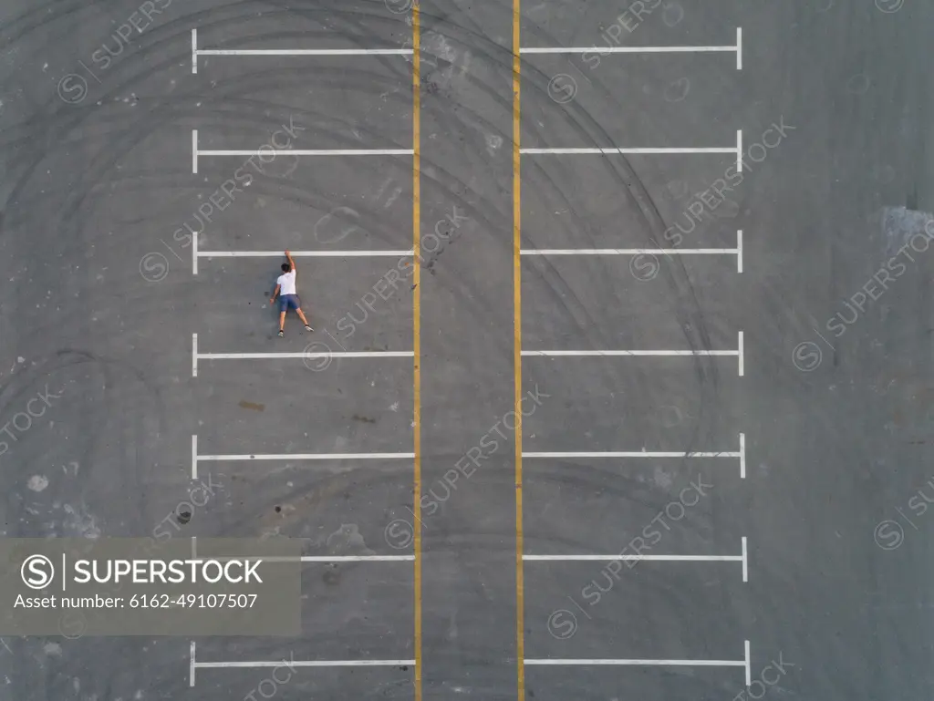 Aerial conceptual view of a man falling from a parking line in Dubai, U.A.E