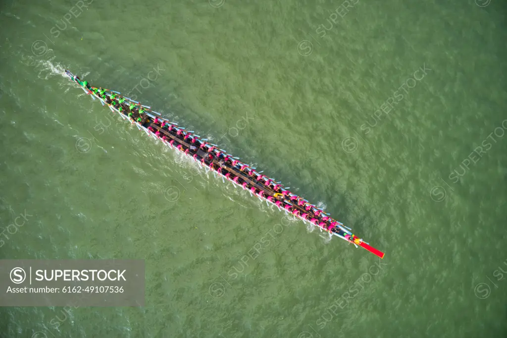 Aerial view of a long canoe for sport activities crossing Meghna river branch near Daudkandi township, Chittagong, Bangladesh.