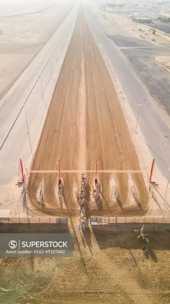 Aerial view of Jockeys and camels on Al Marmoum Camel Racetrack in Dubai, U.A.E.