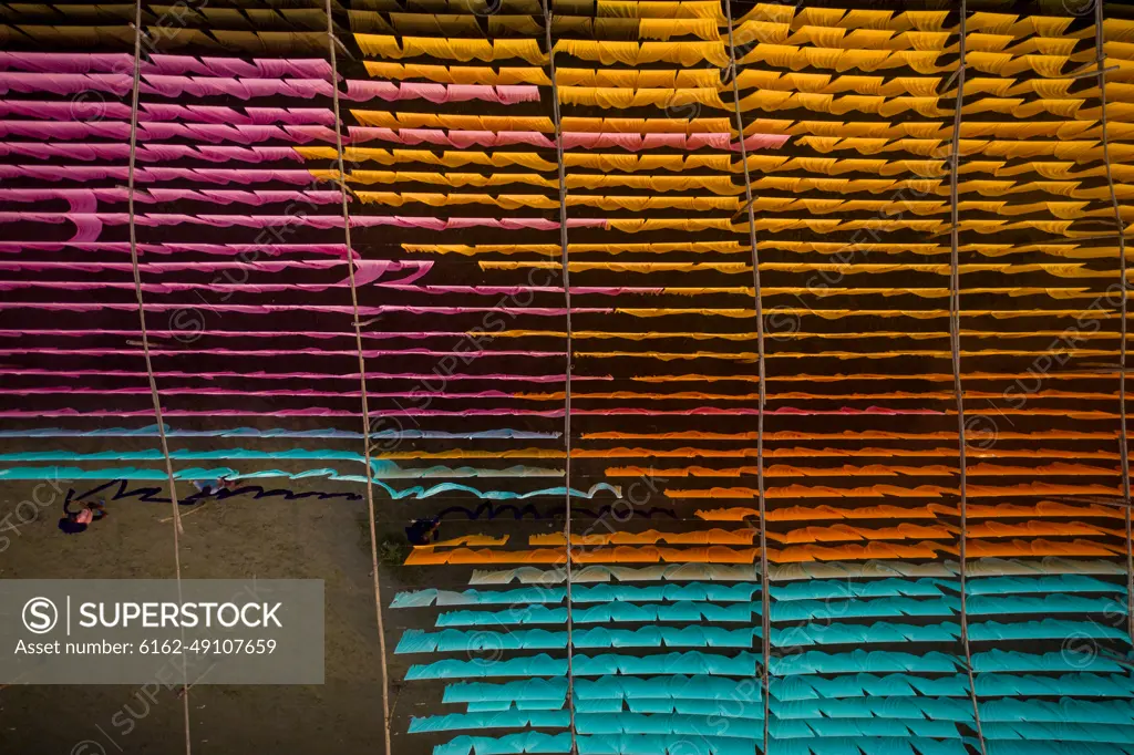 Aerial view of a person working in a public laundry hanging for drying colourful cloth in Narayanganj, Dhaka, Bangladesh.