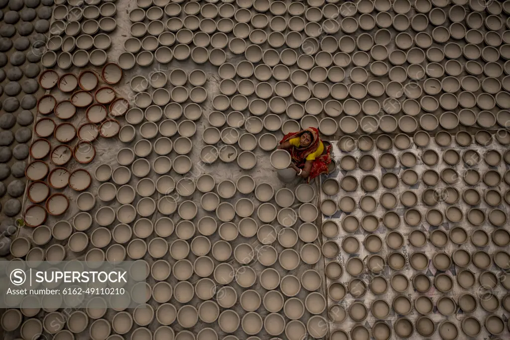 Manikgonj, Bangladesh - 20 February 2022: Aerial view of a woman working with clay pot in Manikgonj, Dhaka, Bangladesh.