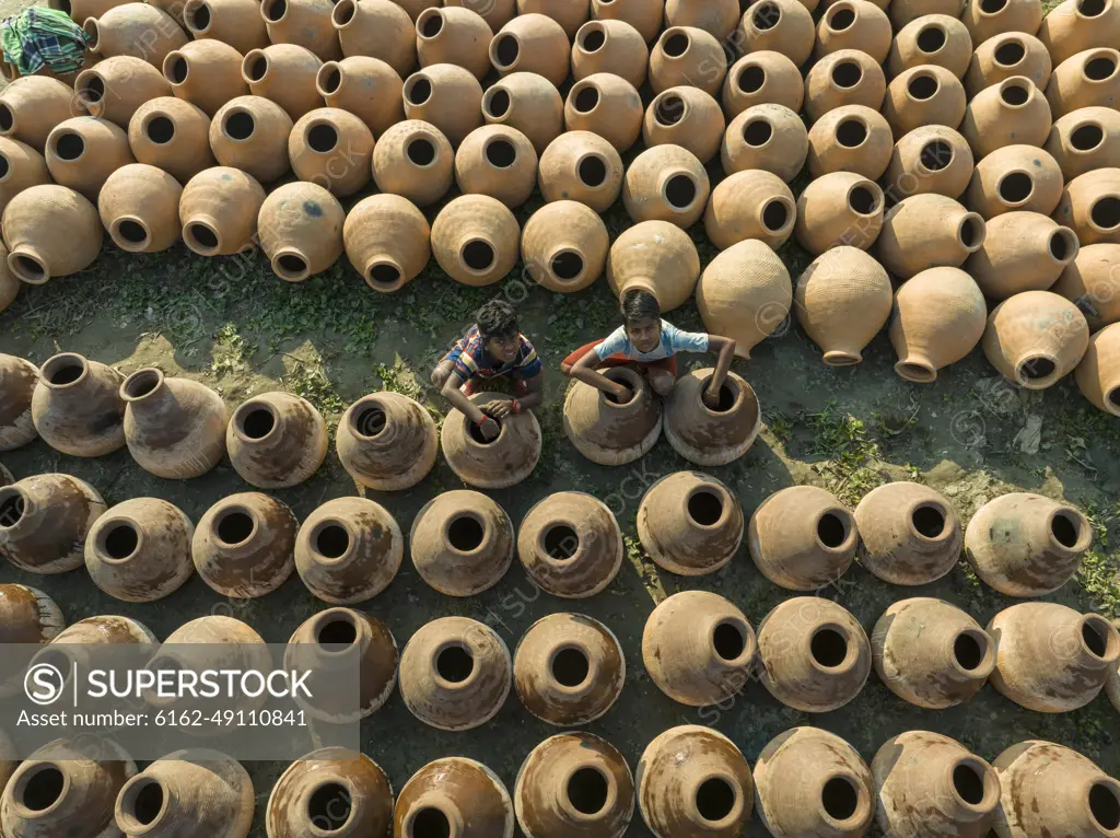 Manikgonj, Bangladesh - 20 February 2022: Aerial view of a kids working with clay pot in Manikgonj, Dhaka, Bangladesh.