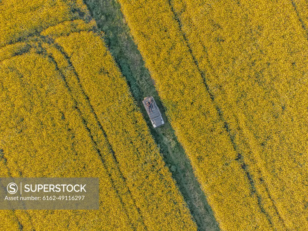 Aerial view of a person relaxing on top of a camper van in La Pera countryside, Girona, Spain.