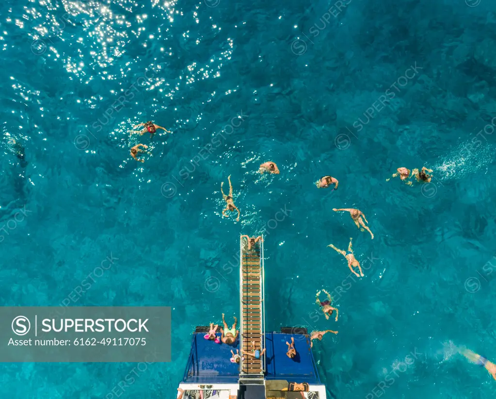 ITHAKI - GREECE, AUGUST 9 2018: Aerial view of people on ferry and swimming in sea, Ithaki island, Greece.