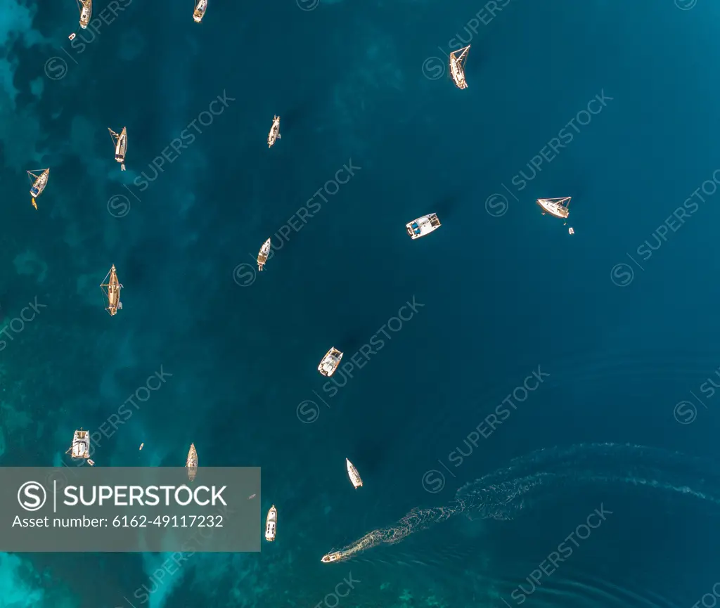 Aerial view of group of boats anchored in the mediterranean sea, Kastos island, Greece.