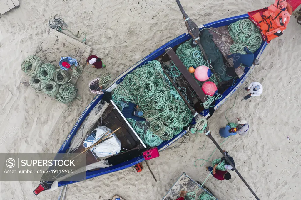 Aveiro, Portugal - 08 August 2020: Aerial view of people along the shoreline prating the Arte Xavega, a Portuguese traditional fishing technique in Torreira, Portugal.