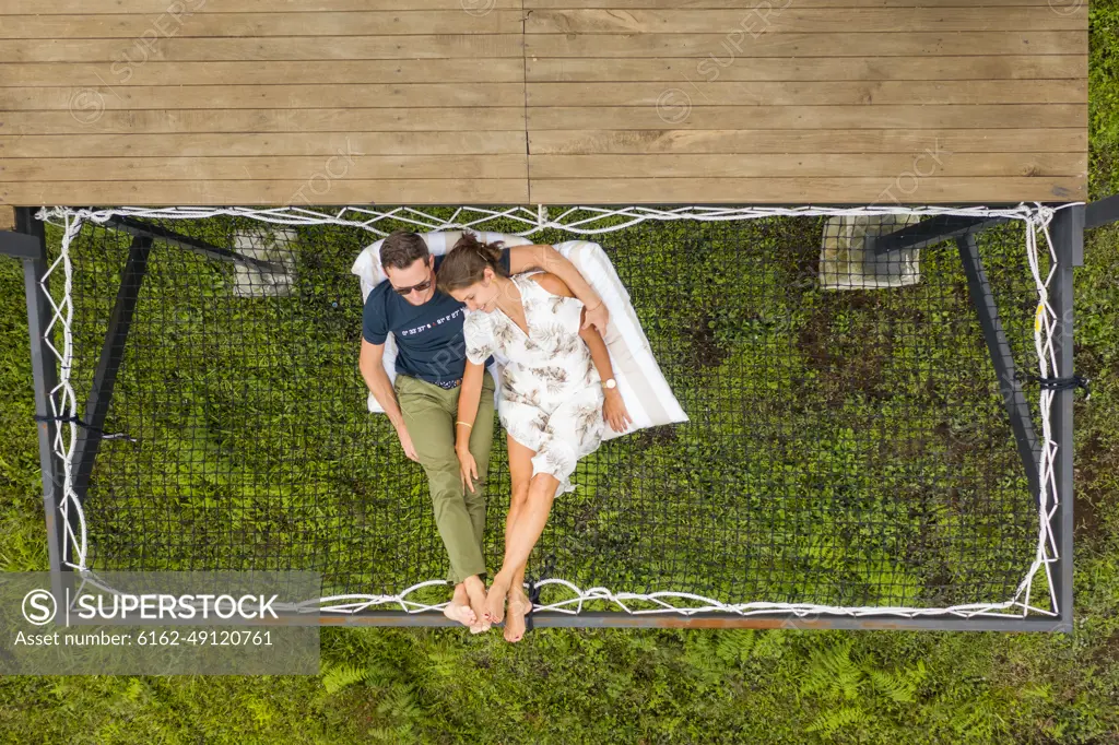 Filandia, Colombia - 08 March 2020: Aerial view of a couple relaxing on a hammock in a campsite, Quindío, Colombia.