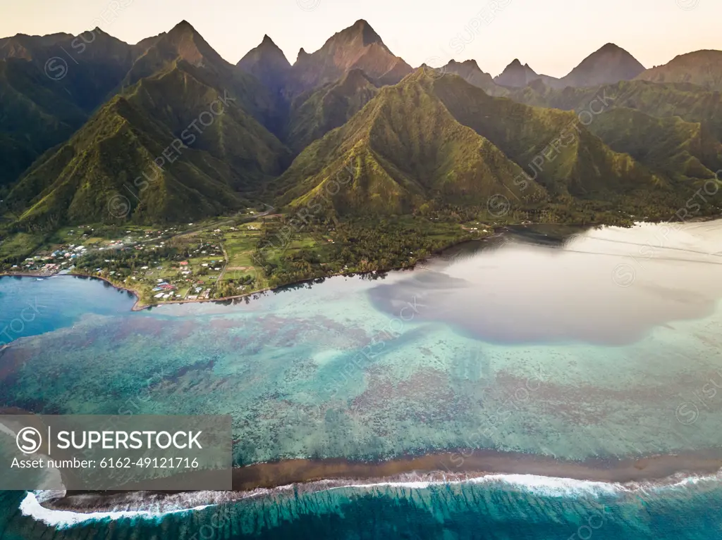 Aerial view of coral reef with The Mighty Mount Aorai in the background in Tahiti, French Polynesia.