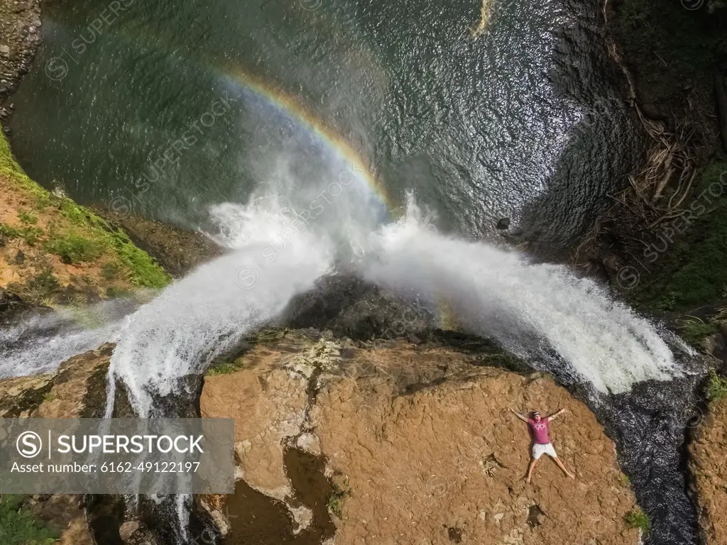 HAWAII - October 15 2016 : Aerial view of a man lying on the top of Wailua falls in Hawaii, USA.