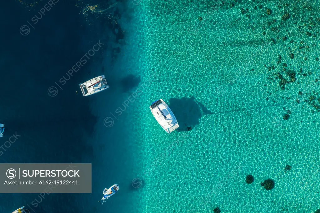 Aerial view of a sailing boat along the reef in Tahiti, French Polynesia.