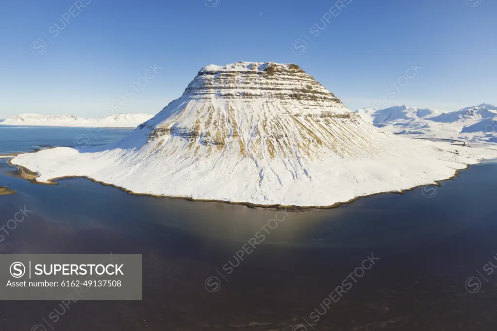 Aerial view of Kirkjufell mountain in winter covered with snow, Snaefellsnes, Iceland.