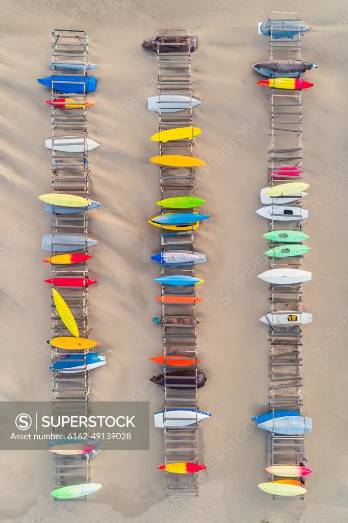 Aerial view of kayaks over the clear sand beach.