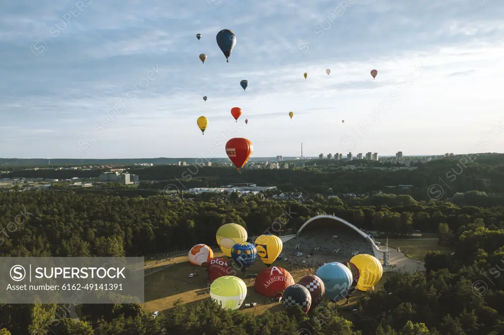 Vilnius, Lithuania - 3 July 2021: Aerial view of hot air balloons taking off from Vingis park and flying over Vilnius in summer time, Lithuania.