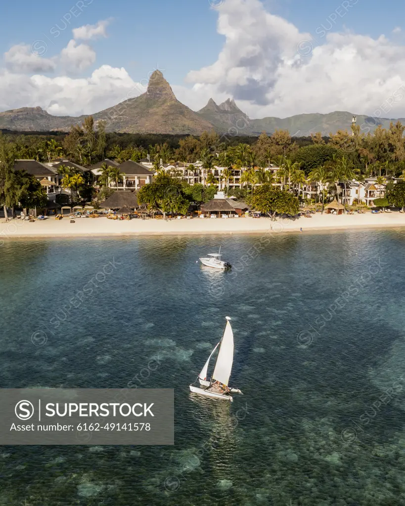 Aerial view of a resort with sailing boat and a mountain range in the background, Flic en Flac, Mauritius.