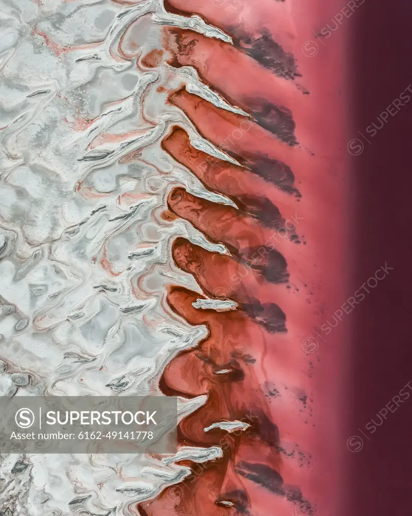 Aerial view of the abstract formations of salt by the banks of the Great Salt Lake seen pink only during some parts of the year in Utah, USA.