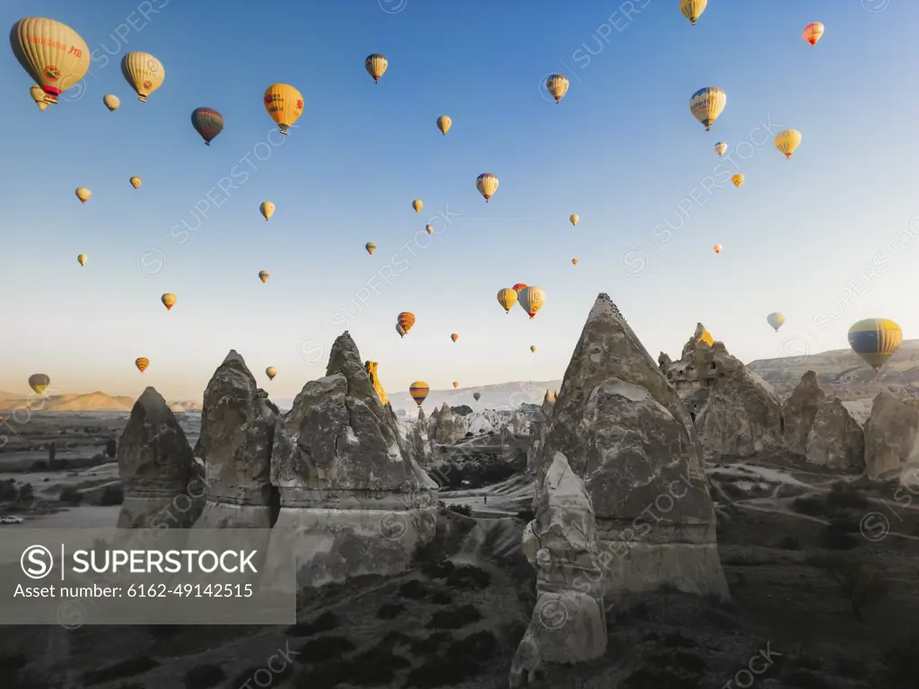 Cappadocia, Turkey - 23 October 2022: Aerial view of hot air balloons at sunrise.