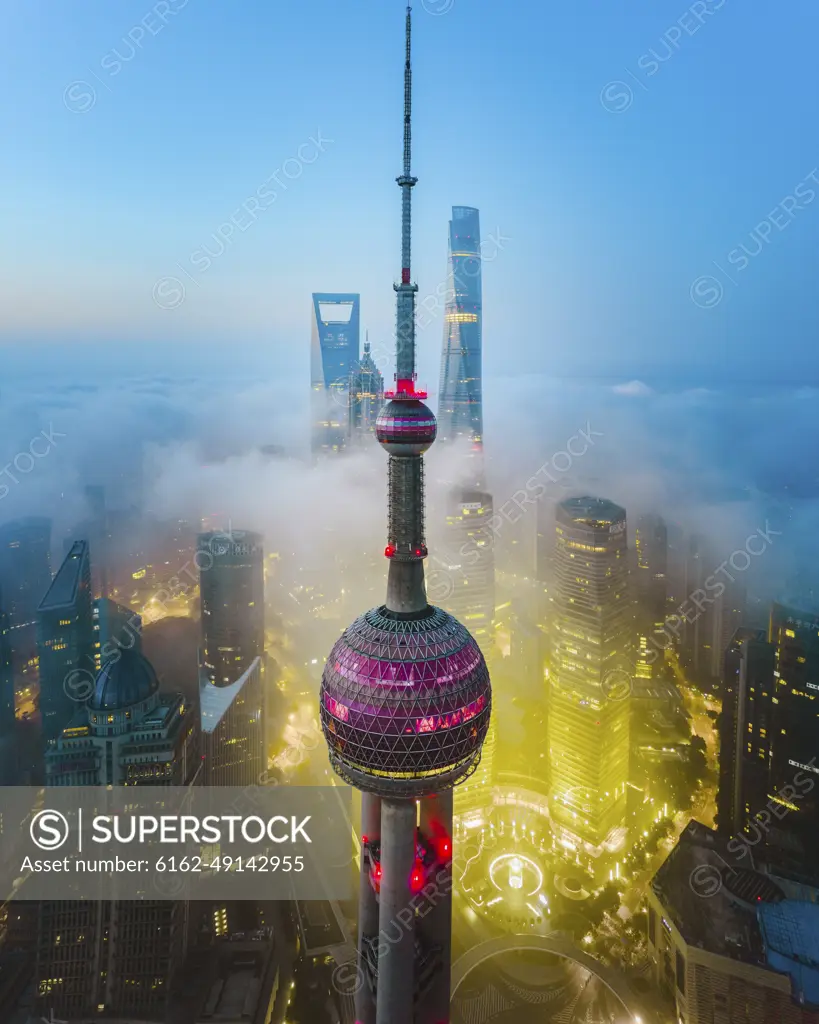 Aerial view of Shanghai Lujiazui tower at sunrise with low fog, China.