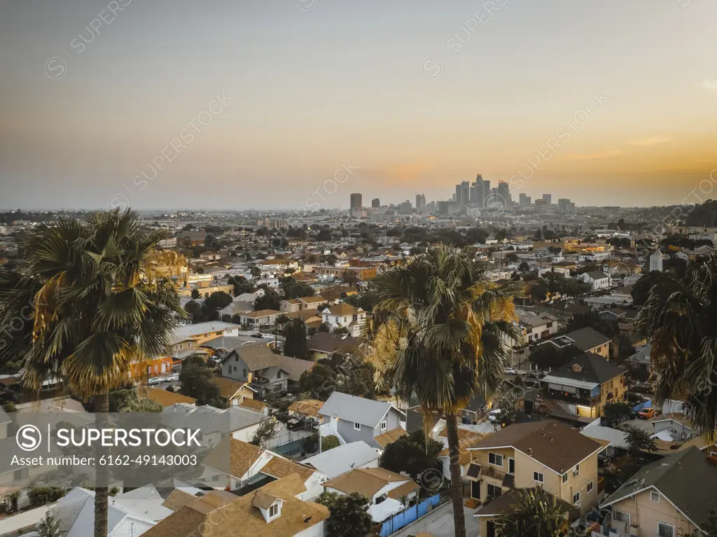 Aerial view of a residential area in California, view of Los Angeles downtown in background at sunset, United States of America.