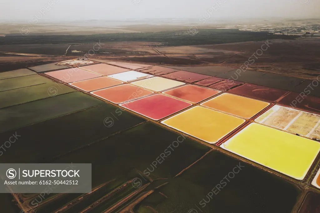 Aerial view of colourful Salinas, salt lakes pool at Farm colony la Algaida, Andalusia, Spain.