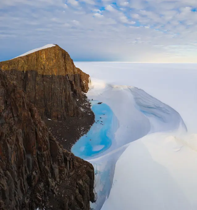 Aerial view of a mountain surrounded by snow in Antarctica